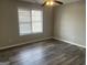Bright bedroom with wood-look flooring, ceiling fan, and natural light at 11 Carriage Lake Dr, Stockbridge, GA 30281