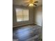 Sunny bedroom with ceiling fan and window featuring wood-look flooring at 11 Carriage Lake Dr, Stockbridge, GA 30281