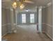 Bright living room with decorative columns, neutral carpet, and multiple windows at 11 Carriage Lake Dr, Stockbridge, GA 30281