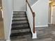 Elegant staircase with wood railing and modern gray wood-look steps and floors at 11 Carriage Lake Dr, Stockbridge, GA 30281