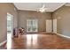 Sunlit living room showcasing hardwood floors, piano and neutral paint, creating a serene ambiance at 106 Deadwood Way, Palmetto, GA 30268