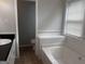 Bright bathroom featuring a white bathtub under a window and a sink with black countertop at 1694 Social Circle Fairplay Rd, Social Circle, GA 30025