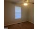 A simple bedroom featuring a ceiling fan, one window, and brown carpeted floors at 1694 Social Circle Fairplay Rd, Social Circle, GA 30025