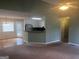 Cozy living room featuring brown carpet, ceiling fan, and an opening to the kitchen and dining area at 1694 Social Circle Fairplay Rd, Social Circle, GA 30025