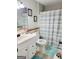Bathroom with white sink, toilet, and a blue and white striped shower curtain, complementing the blue rugs at 3213 Sweetbriar Dr, Villa Rica, GA 30180