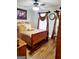 Cozy bedroom featuring hardwood floors, a ceiling fan, and a comfortable bed with decorative pillows and window with curtains at 3213 Sweetbriar Dr, Villa Rica, GA 30180