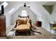 Attic bedroom featuring skylights, a ceiling fan, an armchair, and neutral carpet, creating a cozy and well-lit space at 3213 Sweetbriar Dr, Villa Rica, GA 30180