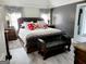 Main bedroom featuring a dark accent wall, a leather bed frame, with a leather chaise lounge, and neutral curtains at 3213 Sweetbriar Dr, Villa Rica, GA 30180