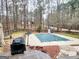 Backyard view with pool featuring a safety cover, grill and deck at 3213 Sweetbriar Dr, Villa Rica, GA 30180