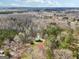 Aerial view showcasing the home nestled in a wooded area with a green roof, surrounded by nature's beauty at 1266 Martin Mill Rd, Moreland, GA 30259