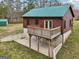 Back view of log cabin featuring a deck and a partial basement, blending natural materials and landscape at 1266 Martin Mill Rd, Moreland, GA 30259