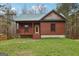 Cozy log cabin with a welcoming front porch and well-maintained lawn, set amongst mature trees at 1266 Martin Mill Rd, Moreland, GA 30259