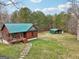 Exterior view of cabin with metal roof plus view of the detached car port and surrounding landscape at 1266 Martin Mill Rd, Moreland, GA 30259