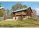 Exterior of home with a green roof and wood siding, featuring a backyard deck at 1266 Martin Mill Rd, Moreland, GA 30259