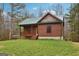 Attractive log cabin with a charming front porch, shed, and lush green lawn under a bright blue sky at 1266 Martin Mill Rd, Moreland, GA 30259