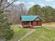 Charming log cabin home with a green metal roof, stone pathway, and a cozy front porch at 1266 Martin Mill Rd, Moreland, GA 30259