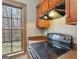 Kitchen features black range, wood cabinets, laminate countertops and window view to the outdoors at 1266 Martin Mill Rd, Moreland, GA 30259
