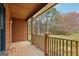 Covered porch featuring wood flooring, log cabin walls, and views of the trees at 1266 Martin Mill Rd, Moreland, GA 30259