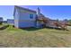 Exterior view of a home with a wood deck, light blue siding, green grass, and a blue sky at 6776 Gina Agha Cir, Lithonia, GA 30038