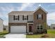 Two-story brick home boasts symmetrical window placement, a gray top facade, and a two car garage at 166 Silverton Dr, Dacula, GA 30019