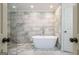 Modern bathroom featuring a freestanding tub with tile flooring and walls, plus stylish fixtures at 2431 Weatherford Ct, Marietta, GA 30068