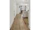 Hallway featuring hardwood floors, white walls, and an open layout, leading to the kitchen and living room areas at 82 Airmont Dr, Sharpsburg, GA 30277
