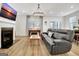 A modern living room with a fireplace, wood floors, a leather sofa, and a unique chandelier at 82 Airmont Dr, Sharpsburg, GA 30277