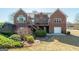 Brick home featuring a wooden deck, walkout basement and well-maintained landscaping at 408 Tomahawk Trl, Mcdonough, GA 30252