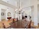 Open-concept dining room leads to the living room with hardwood floors and a chandelier at 408 Tomahawk Trl, Mcdonough, GA 30252