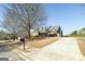 Traditional brick home with dormer windows, a well-manicured lawn, and a long driveway leading to the garage at 408 Tomahawk Trl, Mcdonough, GA 30252