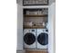 Neat laundry closet with Samsung front loaders, wooden shelves, and ample storage for supplies at 1383 Dolcetto Nw Trce # 9, Kennesaw, GA 30152
