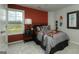 This cozy bedroom features a red accent wall and a window overlooking a verdant landscape at 1716 Goodwin Dr, Hampton, GA 30228
