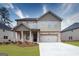 Charming two-story home with brick and siding exterior, featuring a two-car garage and well-manicured lawn at 1716 Goodwin Dr, Hampton, GA 30228
