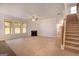 Open-concept living room featuring a fireplace, large windows, and staircase at 1716 Goodwin Dr, Hampton, GA 30228
