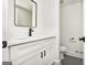 This bathroom features white cabinetry, black hardware, a modern mirror, and tile flooring at 3365 Turtle Lake Se Dr, Marietta, GA 30067