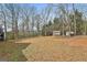 Large backyard showcasing bare trees, wooded area and storage sheds at 1133 Astoria Ln, Peachtree City, GA 30269