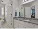 Bathroom with double sinks, granite countertop, white cabinets, and views into the bedroom at 1133 Astoria Ln, Peachtree City, GA 30269