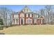 Stunning brick home with a meticulously maintained lawn and mature trees surrounding the property at 1133 Astoria Ln, Peachtree City, GA 30269