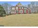 Beautiful brick home with a well-kept lawn, mature trees, and classic architectural details at 1133 Astoria Ln, Peachtree City, GA 30269