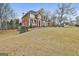Spacious brick home featuring an impeccable lawn with mature trees and elegant architectural design at 1133 Astoria Ln, Peachtree City, GA 30269