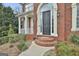 Elegant brick home entrance featuring a black door, and a cozy front porch at 1133 Astoria Ln, Peachtree City, GA 30269
