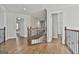 Spacious hallway with hardwood floors, white trim, and staircase with decorative metal railing at 1133 Astoria Ln, Peachtree City, GA 30269