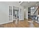 Bright living room featuring hardwood floors, neutral decor, and French doors leading to a home office space at 1133 Astoria Ln, Peachtree City, GA 30269