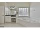 Main bathroom boasts a soaking tub with garden view, vanity, and tile floors at 1133 Astoria Ln, Peachtree City, GA 30269