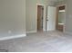 Bright bedroom with neutral carpet, base molding, and multiple doorways for flexible living at 240 Jay Trl, Fayetteville, GA 30215