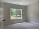 Bright bedroom with carpet, neutral walls, and a large window overlooking the trees at 240 Jay Trl, Fayetteville, GA 30215