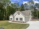A two-story home featuring an attached two car garage and manicured lawn with wooded surroundings at 240 Jay Trl, Fayetteville, GA 30215