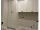 Laundry room featuring white cabinets for storage and marble tile floors at 240 Jay Trl, Fayetteville, GA 30215