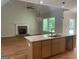 Open concept living room and kitchen featuring hardwood floors and a stone fireplace at 240 Jay Trl, Fayetteville, GA 30215