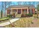 Charming brick home featuring a covered porch with wood railing and a well-manicured front yard at 150 Gill Ln, Stockbridge, GA 30281